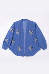 Blue denim jacket with floral embellishments on a white background